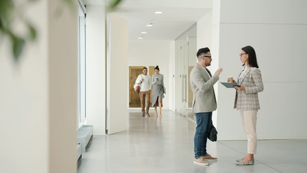 Colleagues in candid conversation in a bright modern office
