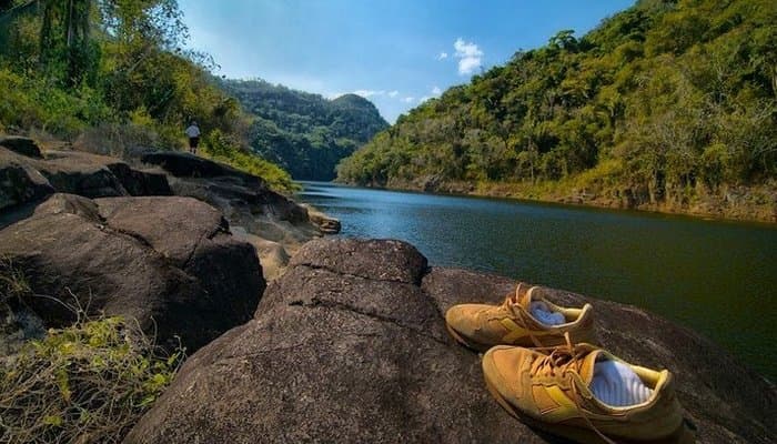 River view with hiking shoes on the rocks