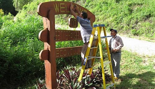 Locals installing the Welcome sign at the community entrance