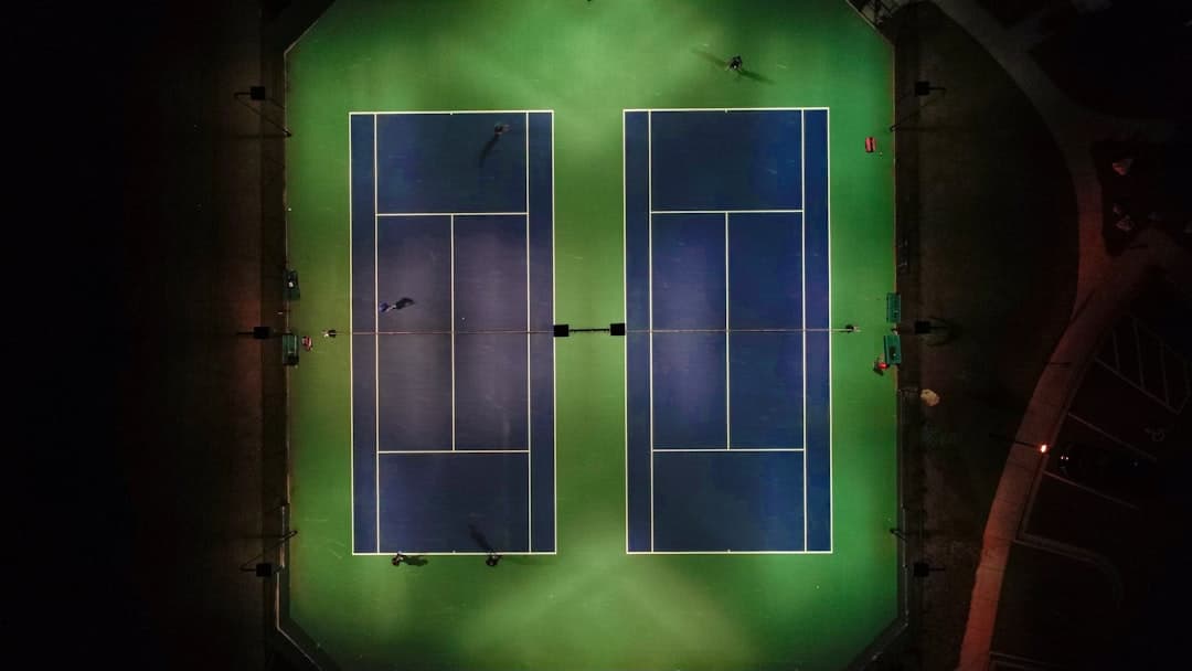 grand empty tennis stadium at night floodlit court dark cavernous stands cinematic