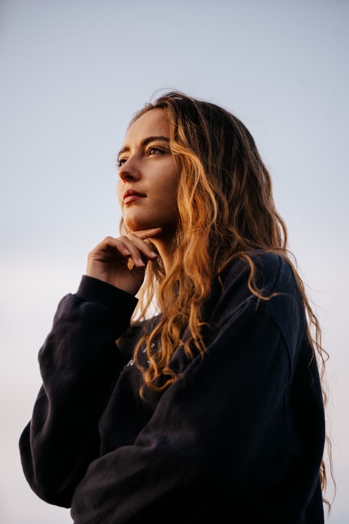 A woman in business reflecting with quiet confidence