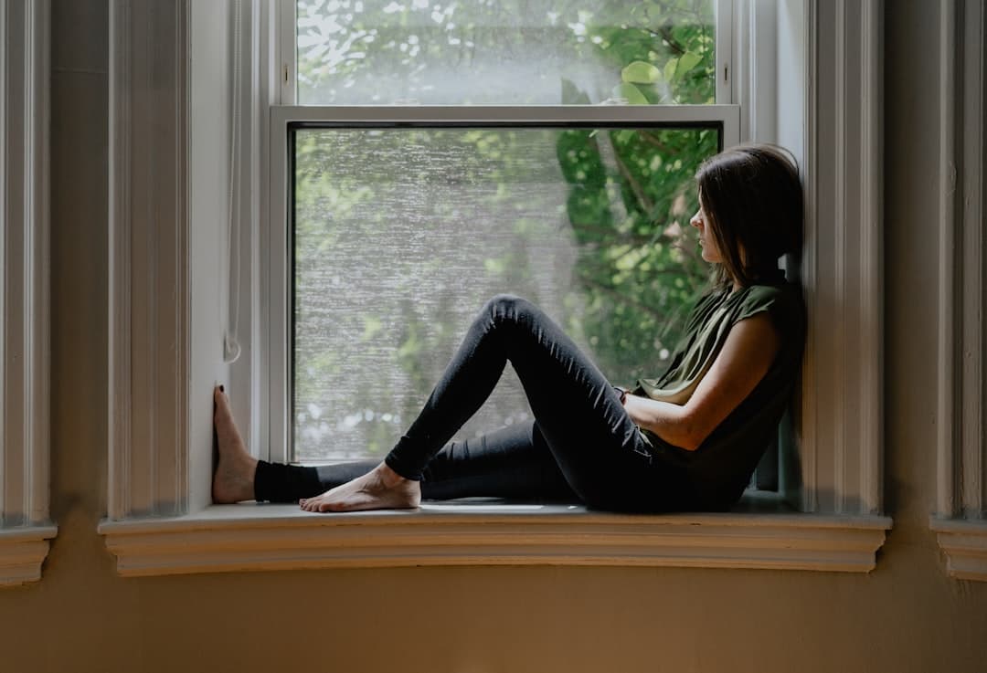 A person pausing to reflect by a window