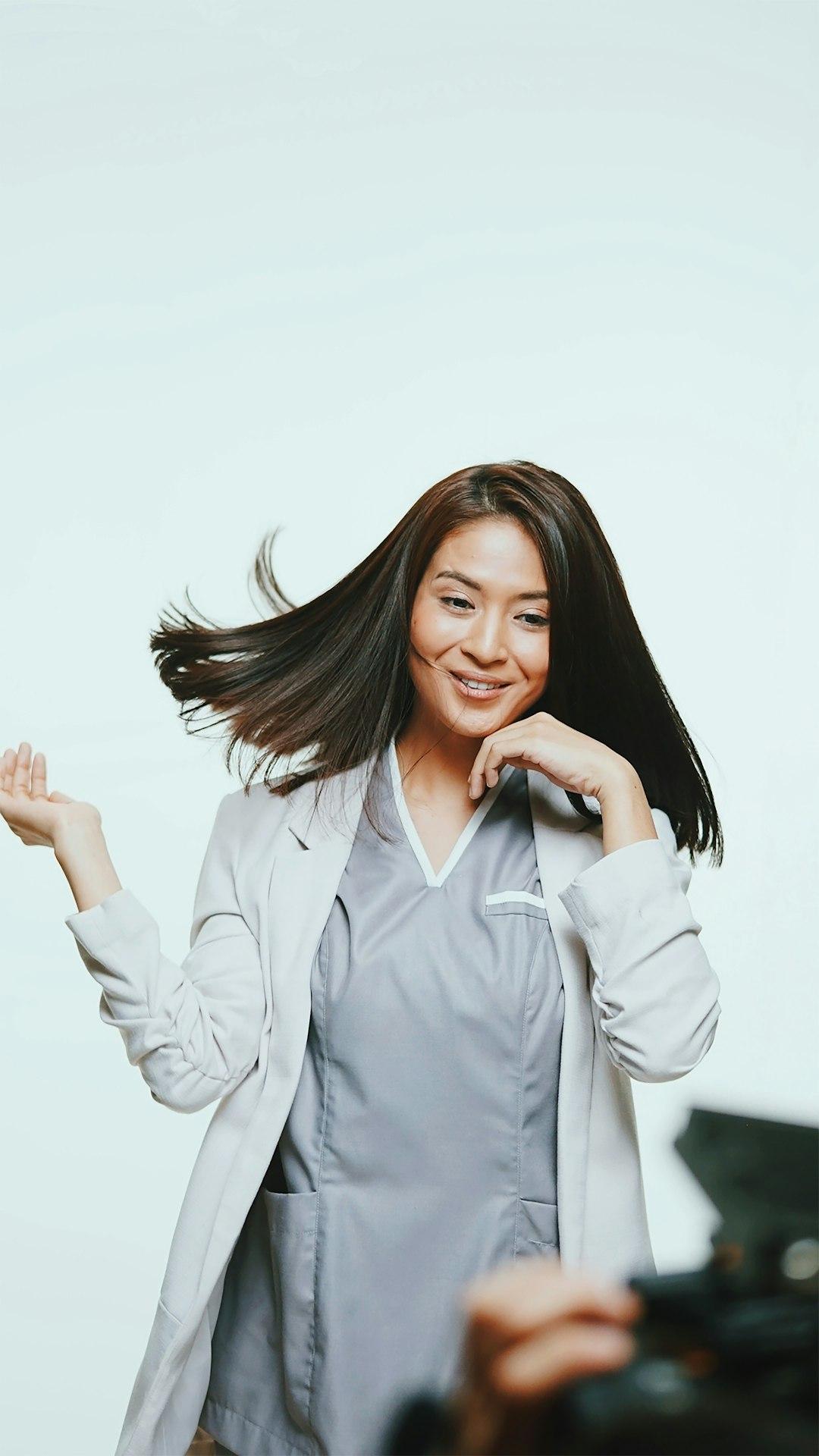A relieved, smiling woman patient with her face visible speaking with a female doctor in a clinical setting