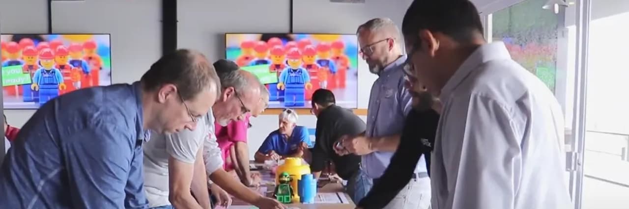 Hands sorting coloured bricks on a table