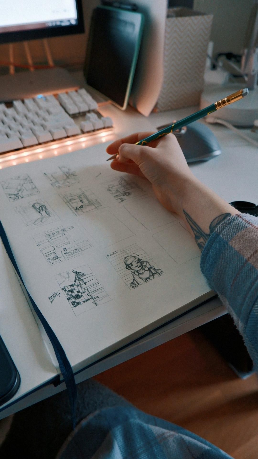 Hands sketching a process flow in a notebook