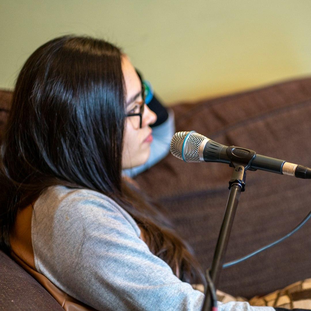 A voice-over artist speaking into a studio microphone