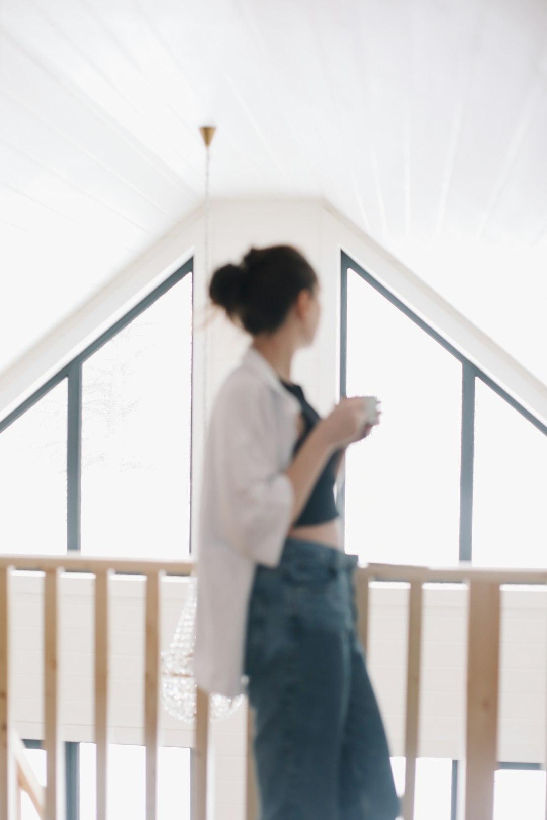 A person opening a window at home