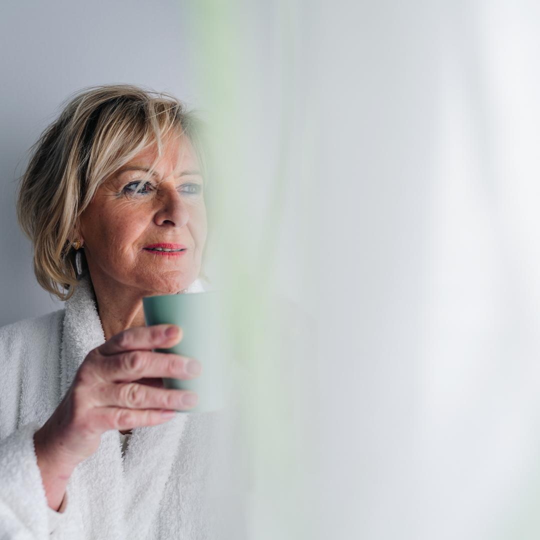 A woman in her sixties walking outdoors in soft morning light