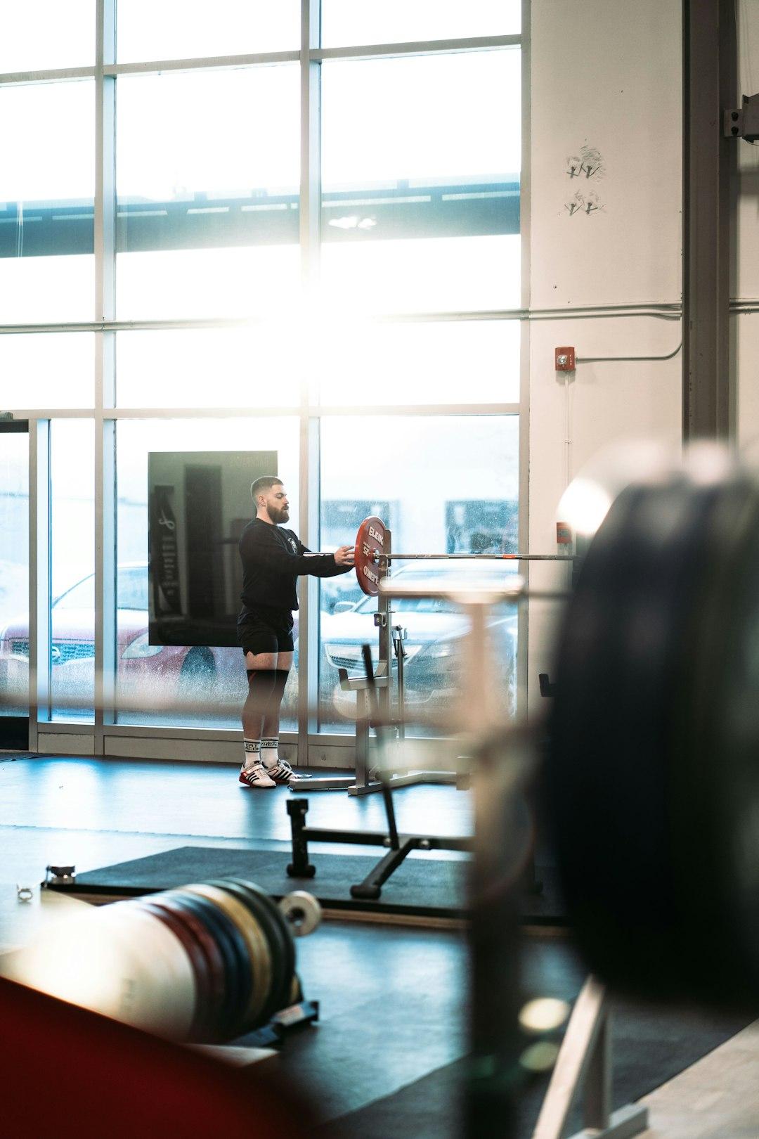 A coach guiding a lifter through a barbell set