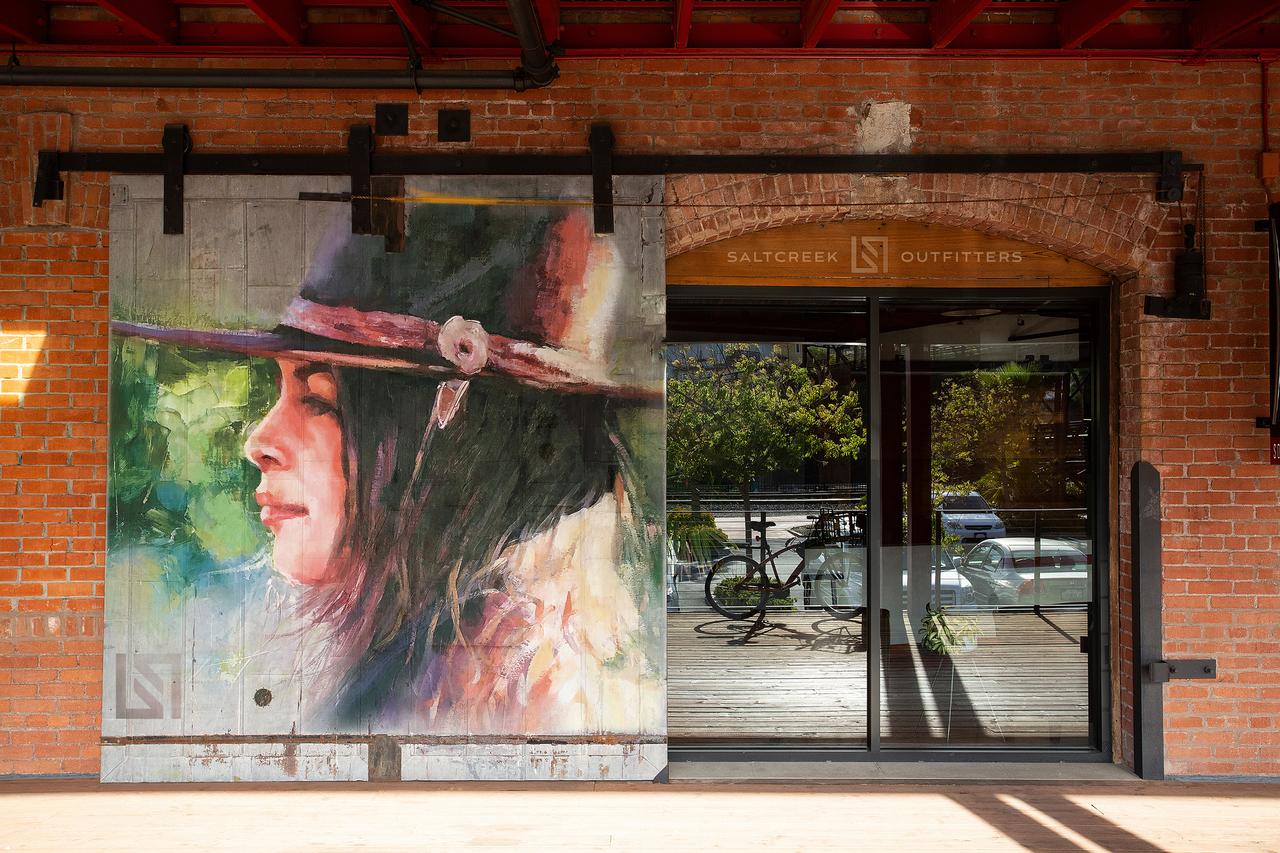 An artist installing framed original artwork in a lobby