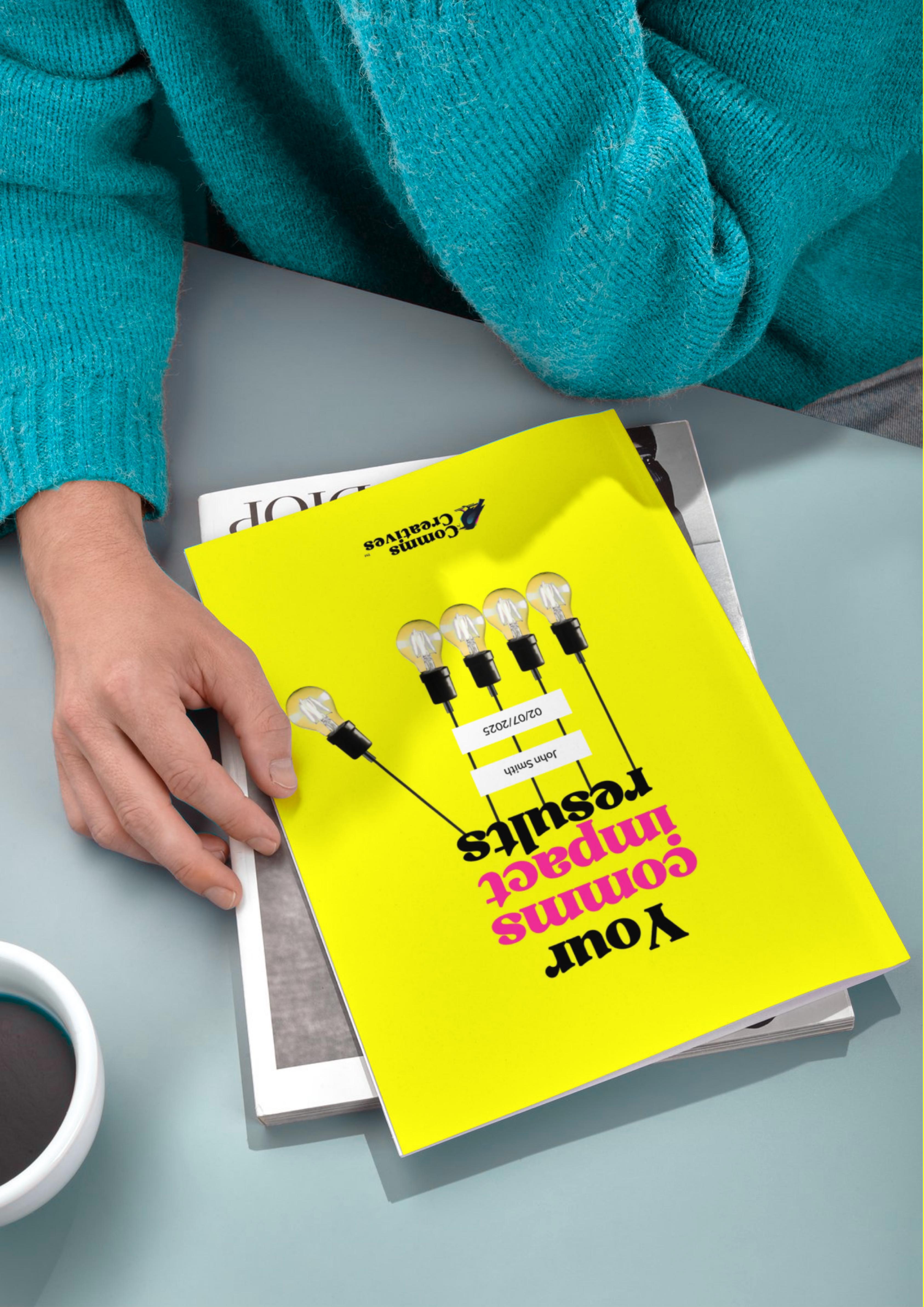 Elbows and arms in bright blue jumper read a report with the cover text that reads 'your comms impact results'