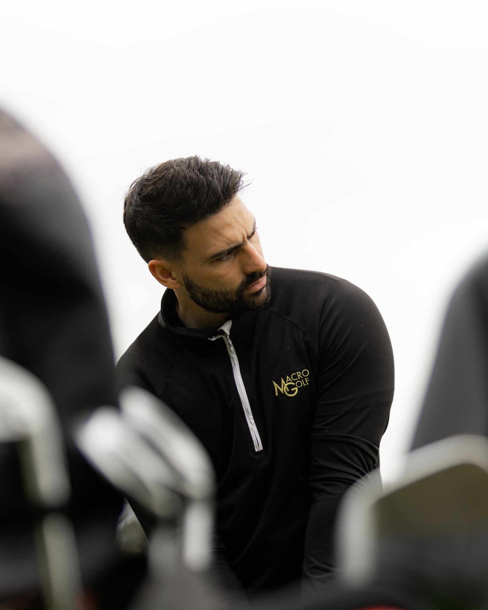 Macro Golf coach studying a shot between clubs