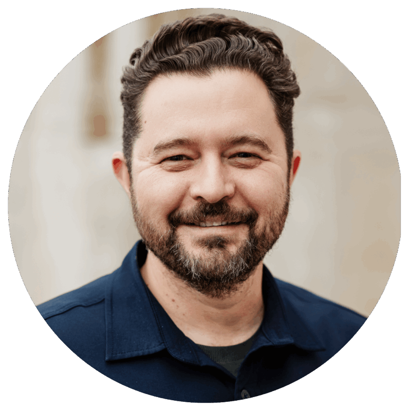 Daniel Priestley smiling in a professional headshot, wearing a navy blue shirt