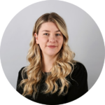 Smiling woman with long wavy blonde hair wearing a black top, professional headshot for ScoreApp partner page.