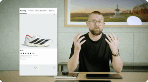 Presenter gesturing beside an adidas product listing showing Adizero Takumi Sen 11 Shoes at 170 pounds with 4.5 stars and 74 reviews